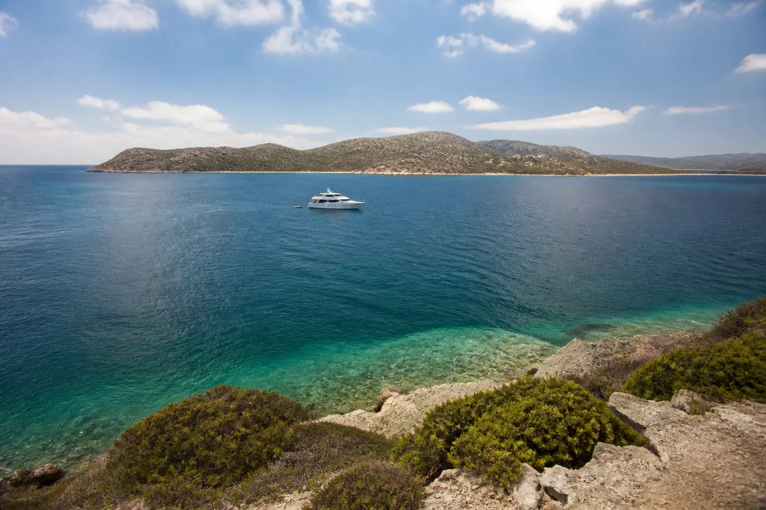Yacht off a remote undeveloped coastline